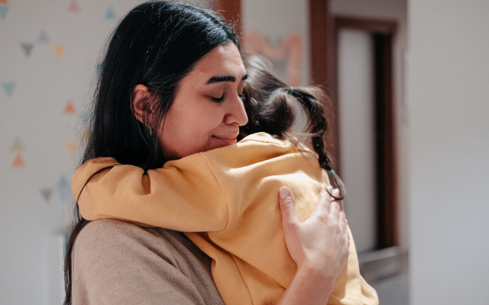 Parent giving a child a hug to help them co-regulate. 