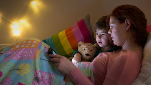 Parent reading social story to child at bedtime. 