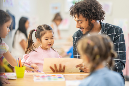 Teacher working with child in classroom. 