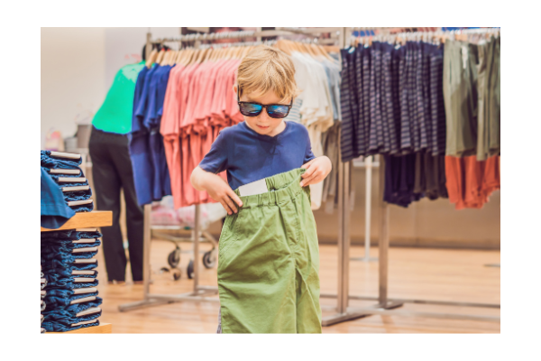 Child doing back to school shopping, trying on new clothes. 